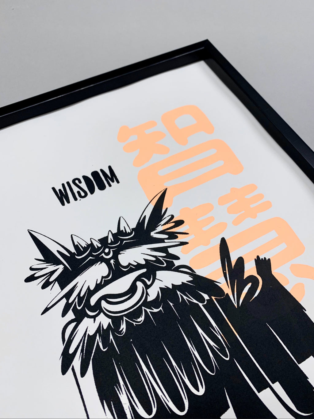 Close up of print with dog-like mythical creature with text wisdom in black and Chinese character of wisdom in fluorescent orange on white paper.